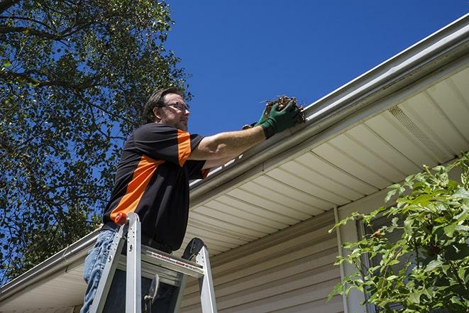 a skilled technician repairing a gutter on a house in Afton